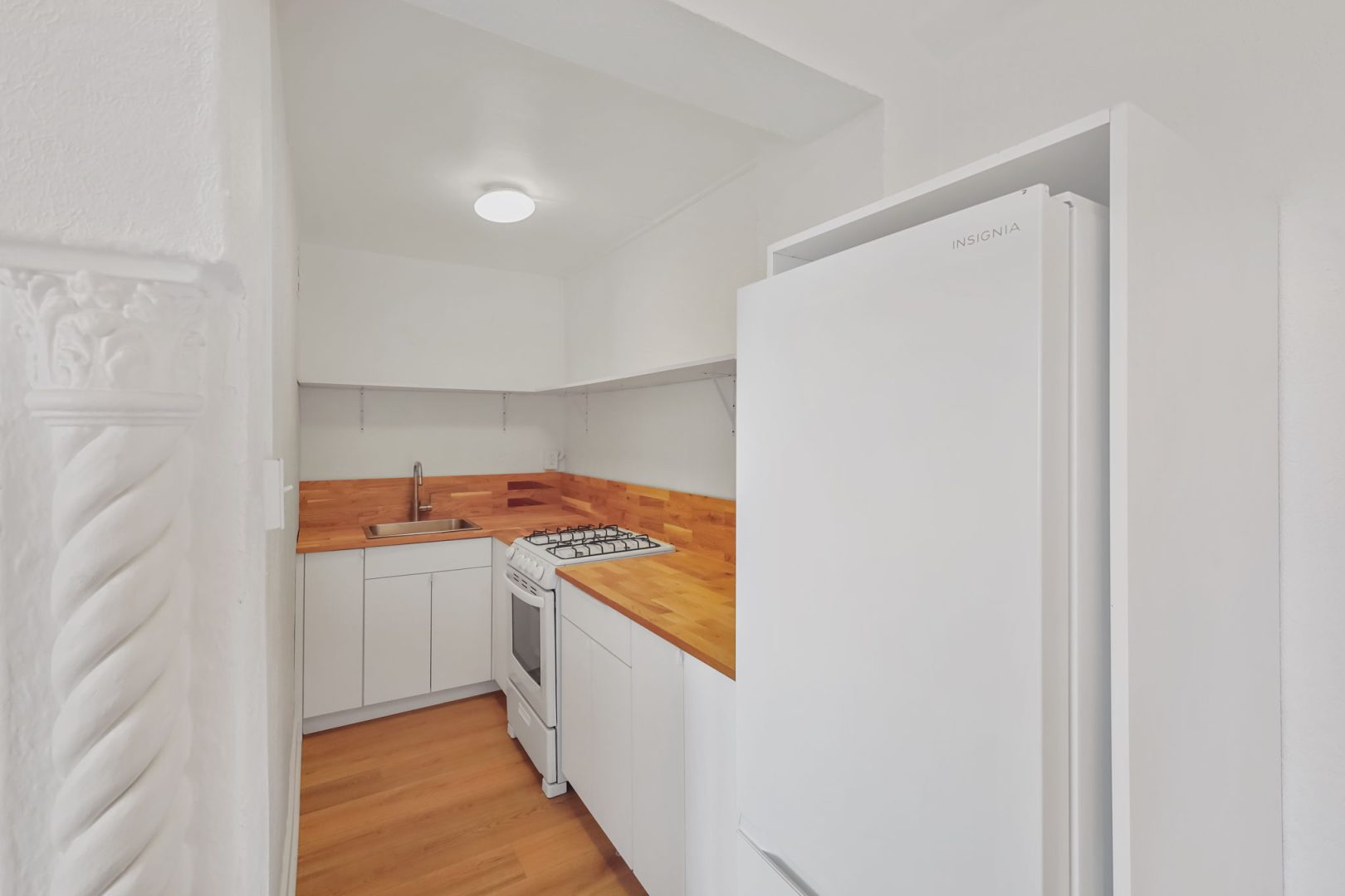 a small kitchen with a refrigerator and stove at The St Regis Apartments