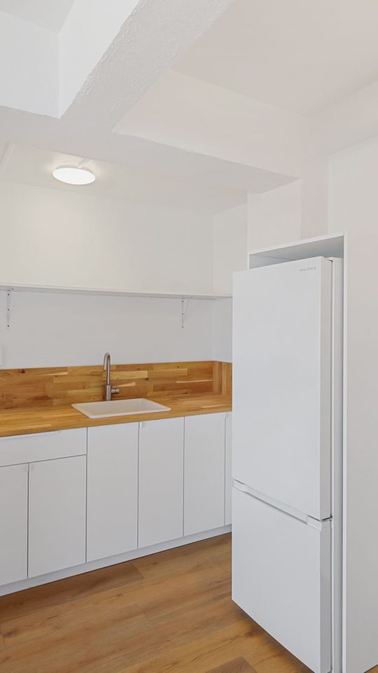 a white kitchen with a stove and refrigerator at The St Regis Apartments