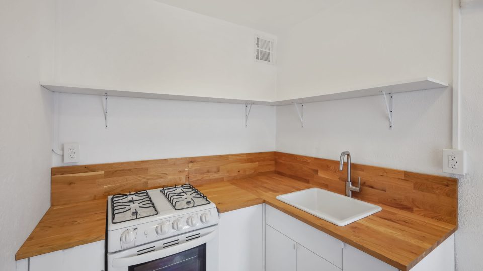 a kitchen with a stove and sink in it at The St Regis Apartments