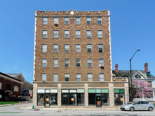 a large brick building on a corner in a city at The St Regis Apartments